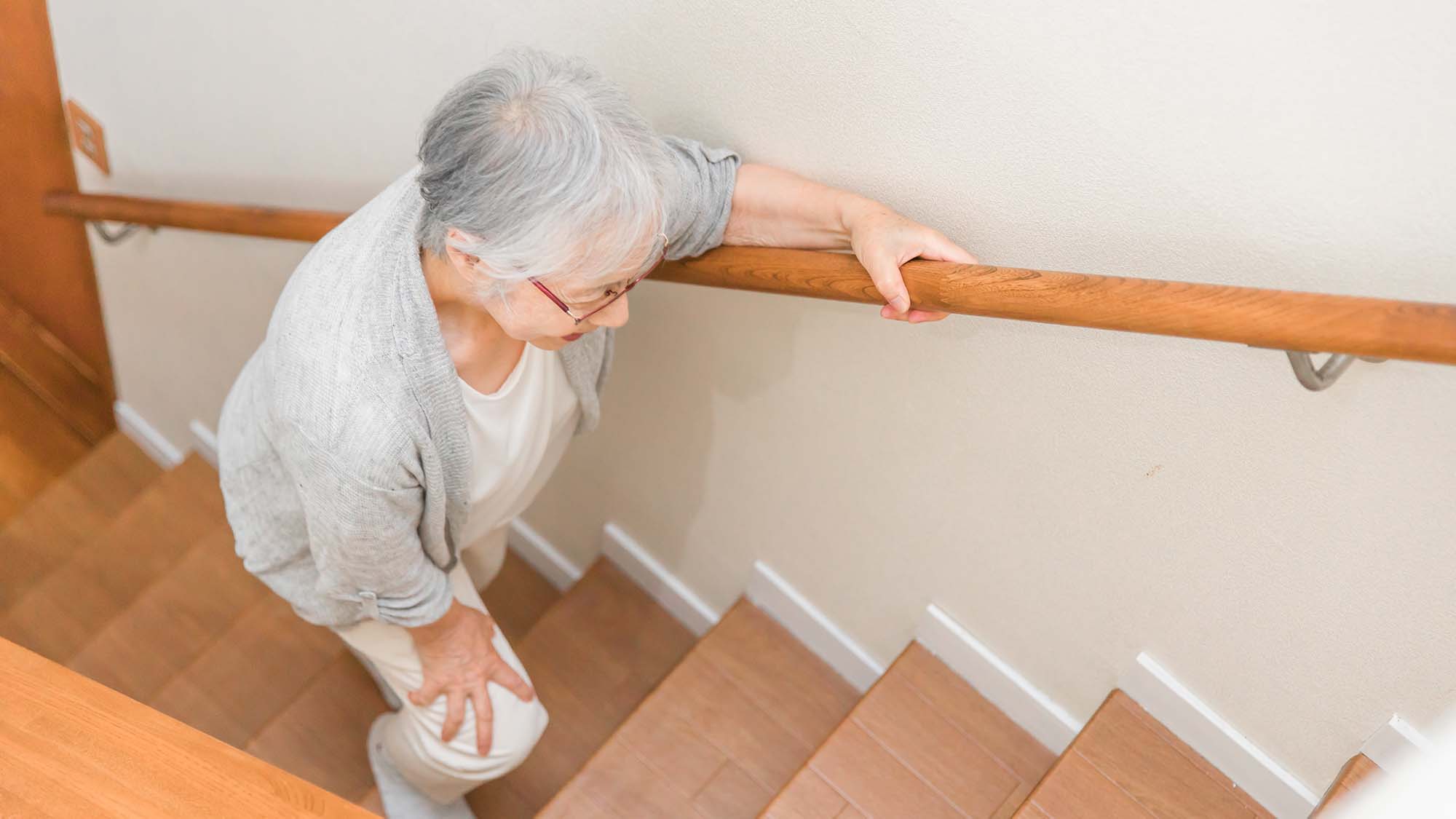 An older woman climbing stairs 